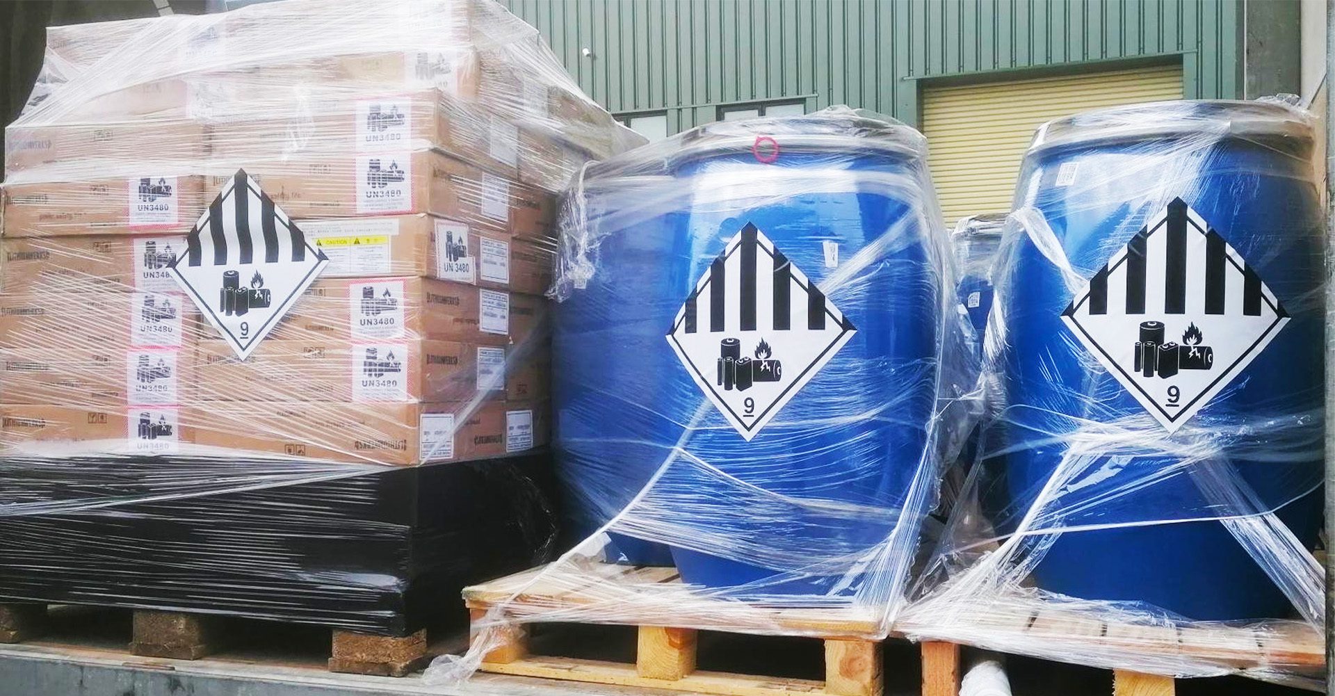 A blue barrel sitting on top of pallets.